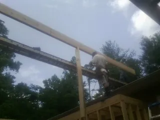 Carpenter setting a ridge beam over a new addition frame — Ice Dam Removal by Roofing Brothers in Marysvale