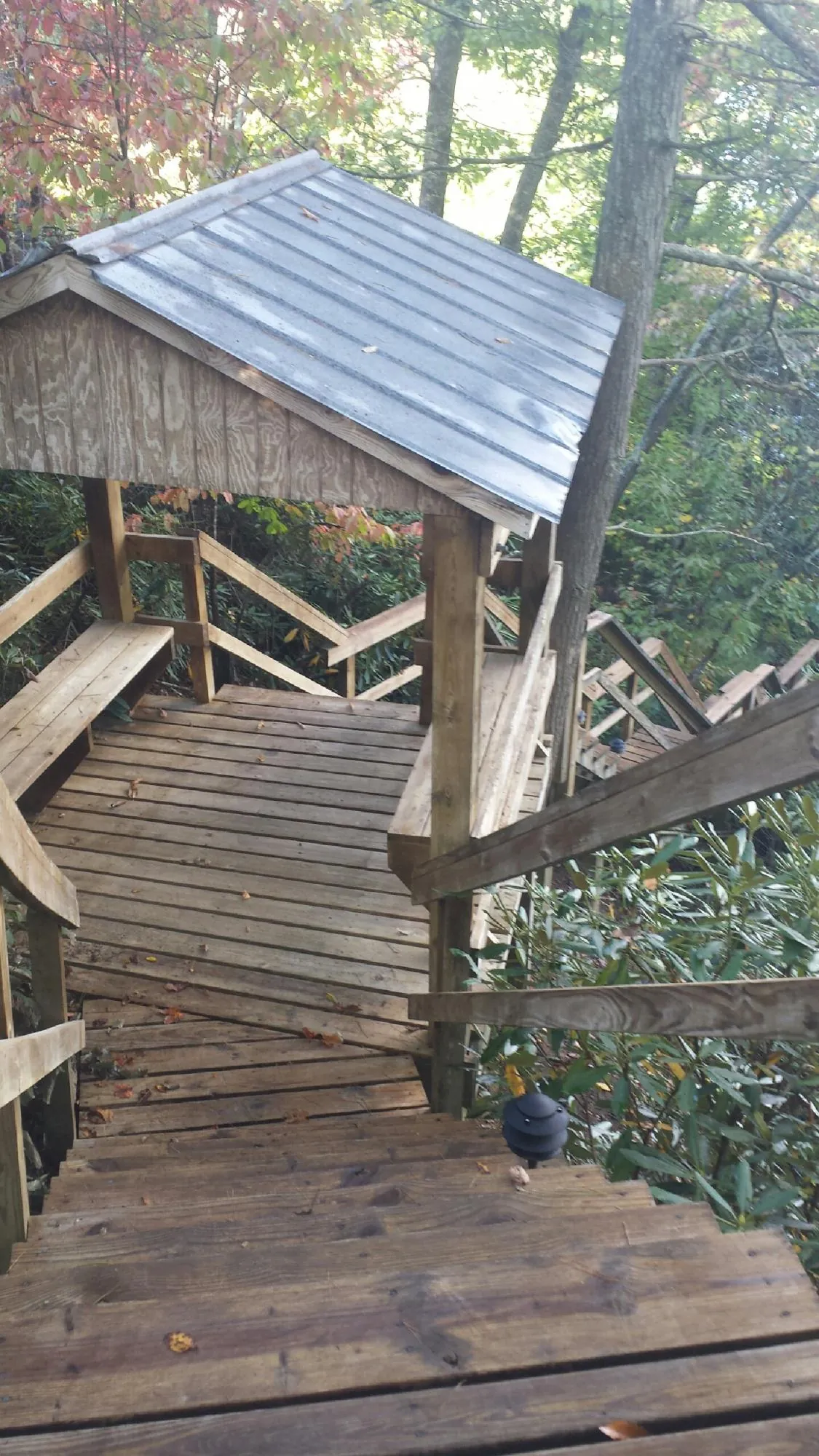 Metal roofed shelter over wooden steps on a wooded walkway — Skylight Repair & Installation work by our crew in Marysvale